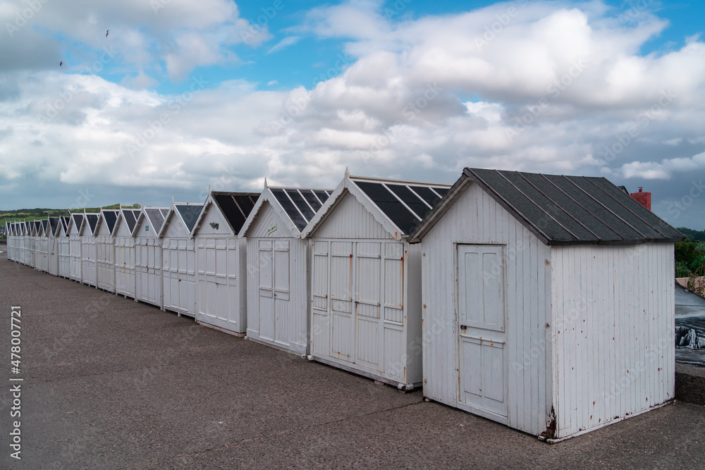 Hautot sur Mer, France - July 30, 2021: White wooden beacj bathing boxes at Hautot sur Mer