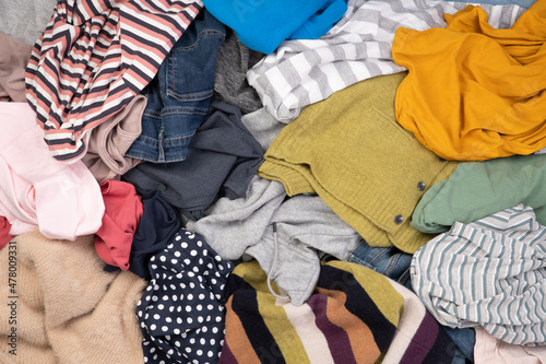 Heap of various colourful clothes such as sweaters, trousers and shirts, top view