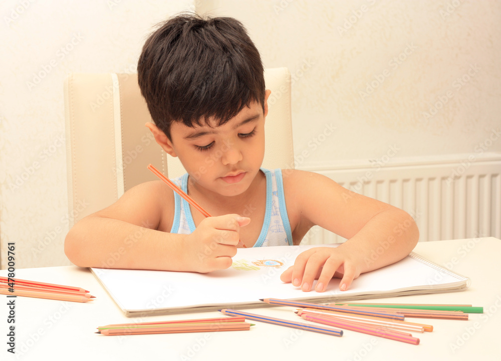 Little boy sitting and drawing with color crayons Little boy sitting and drawing with color crayons