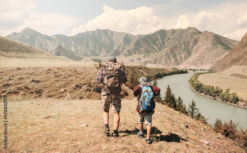 Father and son hikers walking in the mountains Father and son hikers walking in the mountains