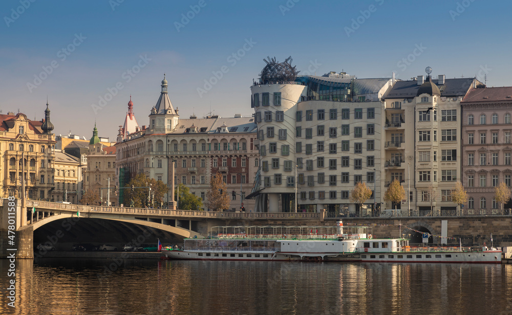 Dancing house in Prague in the Czech Republic with a boat on the river Vltava
