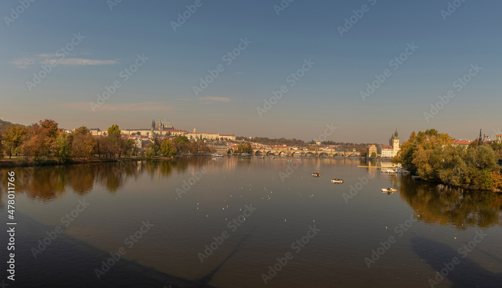 View of the Charles Bridge and the Vltava River on a sunny day in the city of Prague with a boat on the surface