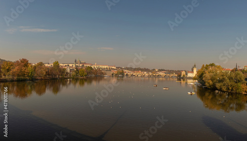 View of the Charles Bridge and the Vltava River on a sunny day in the city of Prague with a boat on the surface