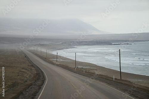 Landscape view of empty road next to the ocean on a foggy morning. Road part of the Pan-American Highway. Photo taken just outside Puerto de Chala in the Arequipa region in Peru, South America. photo