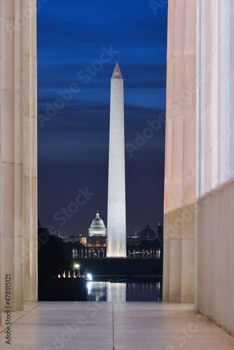 Washington DC monuments including the Capitol and Washington Monument as seen between columns of Lincoln Memorial at night