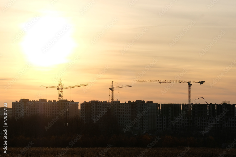 Cranes at the sunset work on the construction of modern resedential district near Tula, Russia