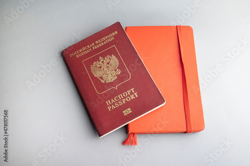 Russian pasport and red note book on grey background photo