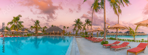 Fotografija Luxury infinity pool sunset sky in a summer beachfront poolside chairs hotel resort at tropical landscape