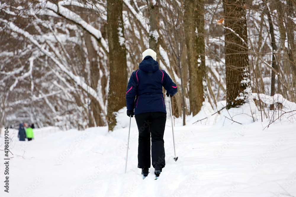 Woman skiing in winter park. Leisure outdoors, female skier walking by snow