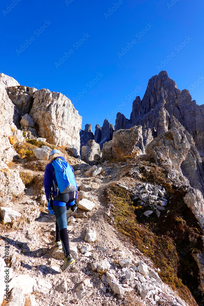 Young woman trekking on the via ferrata of Monte Paterno. Adventure activity in Dolomites, Italy Young woman trekking on the via ferrata of Monte Paterno. Adventure activity in Dolomites, Italy