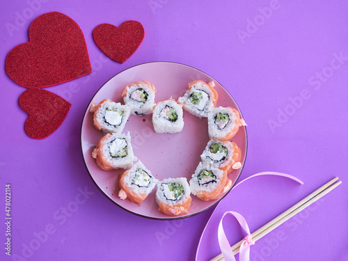 Sushi set in the shape of a heart on very peri background. Valentine day or March 8th food concept.The concept of a romantic dinner at a sushi bar for February 14th.