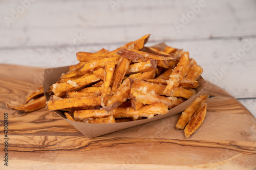 Sweet potato fries on paper container in wood board photo