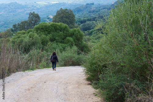 Mujer excursionista con mochila en un camino rural