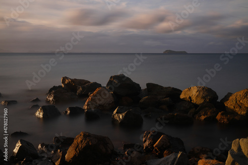 Long exposure image of Dramatic sky seascape with rock in sunset scenery background.Beautiful sunrise or sunset seascape scenery over sea Epic dawn sea landscape with rocks in the foreground. © bt1976