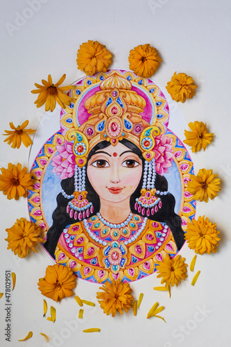 Beautiful goddess Lakshmi with flowers and ornaments painted in watercolors and surrounded by fresh yellow flowers.