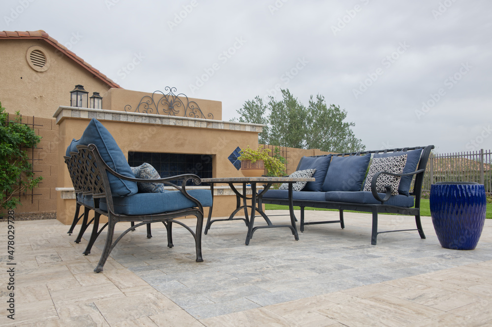 Blue lounge chairs on a travertine Tile pool deck.