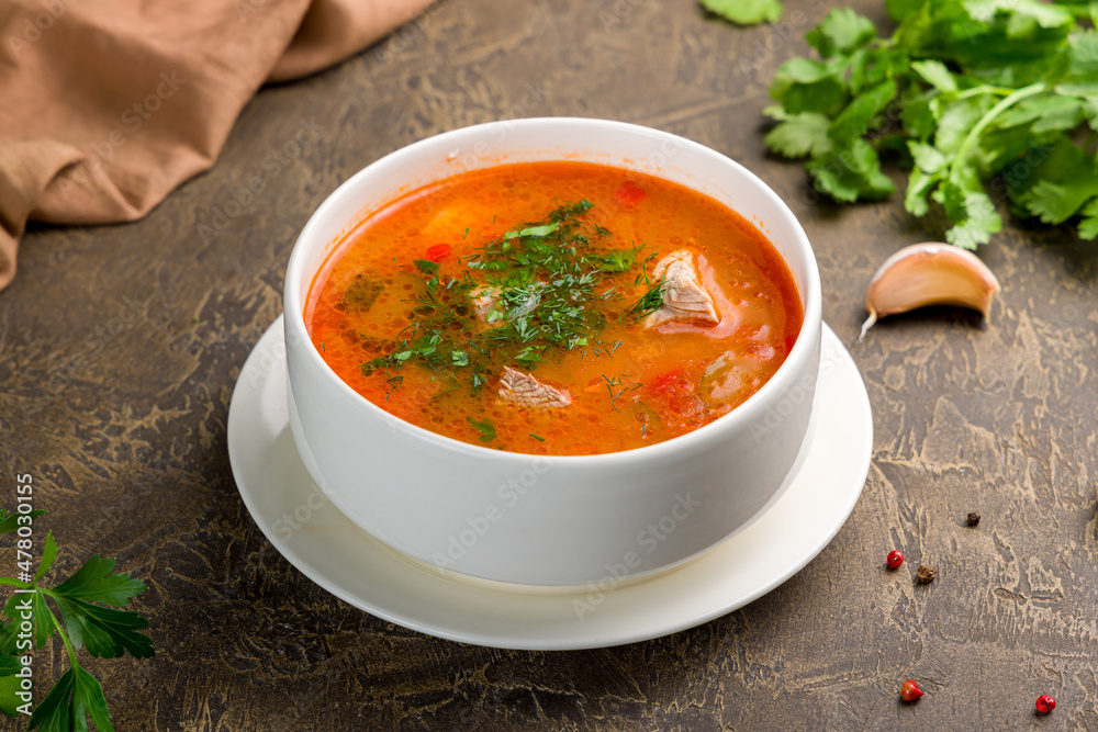 soup kharcho on bowl with meat on brown table soup kharcho on bowl with meat on brown table