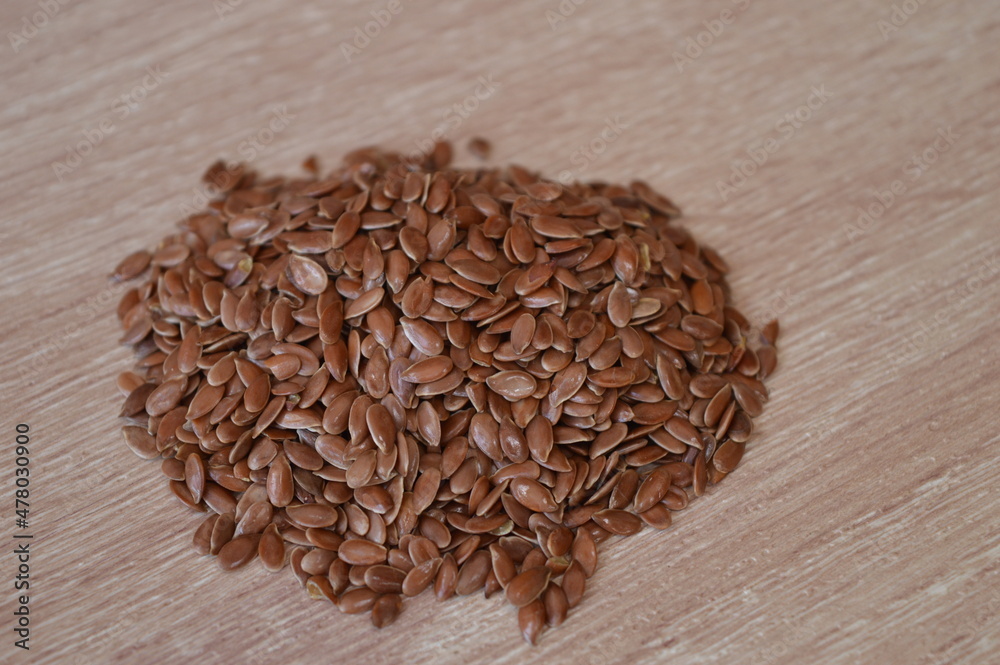flaxseed on a wooden background. flax is very healthy as an addition to the diet because it lowers cholesterol and cleanses blood vessels.