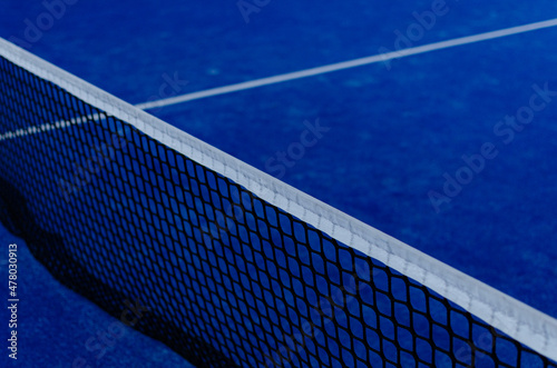 Blue paddle tennis court netting at night