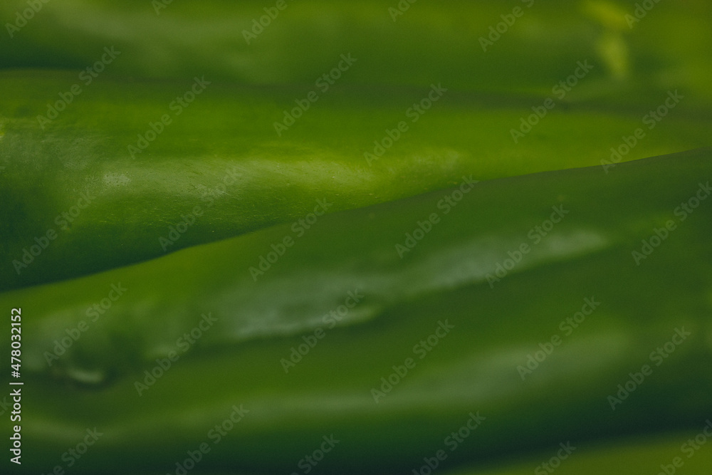 close up view of green peppers texture - dark green background close up view of green peppers texture - dark green background