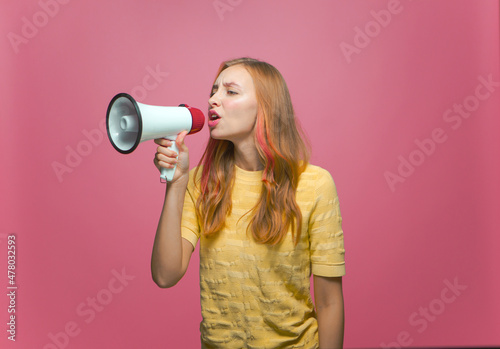 Modern young girl with megaphone. Woman announce news using loudspeaker. Advertising and business promotion concept