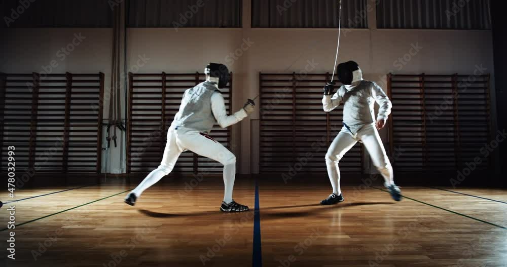 Two Men In Fencing Gear Duelling With Foils Two Men In Fencing Gear Duelling With Foils
