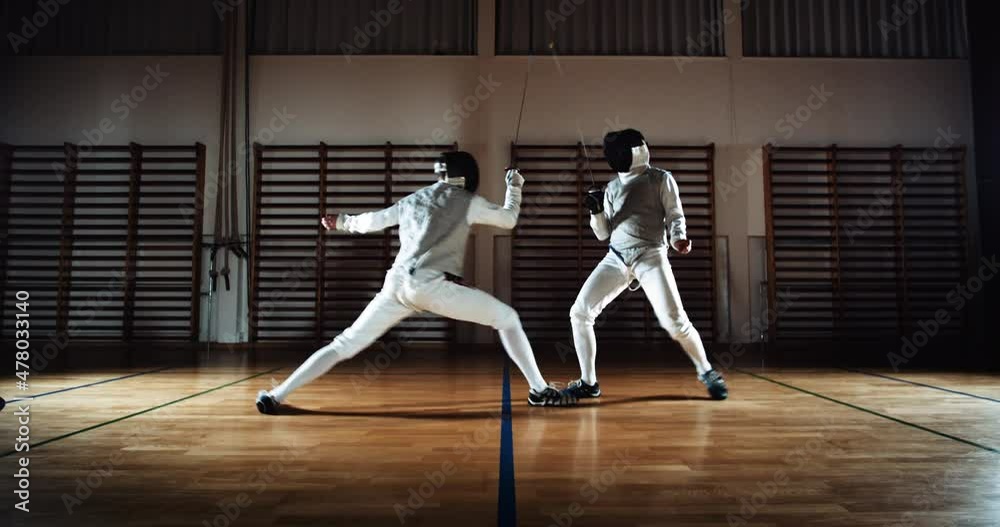 Two Men In Fencing Gear Duelling With Foils Two Men In Fencing Gear Duelling With Foils