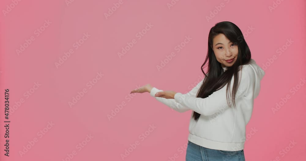 Hospitable friendly smiling young asian girl welcoming, inviting to come in, showing copy space for advertising Hospitable friendly smiling young asian girl welcoming, inviting to come in, showing copy space for advertising