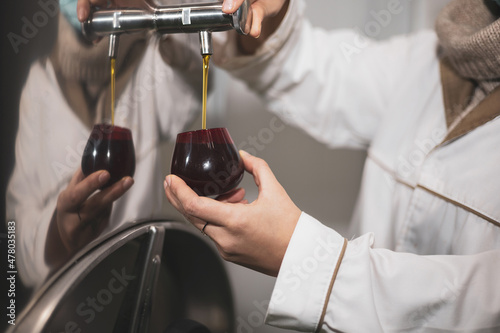 Canvastavla A worker obtains a small sample of virgin olive oil for a tasting in an oil mill
