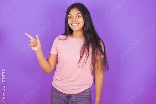 Hispanic brunette girl wearing pink t-shirt over purple background pointing up with fingers number eight in Chinese sign language BÄ.