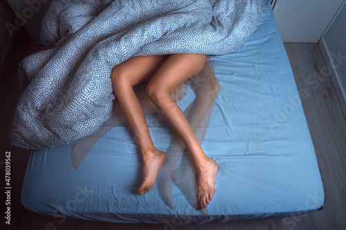 Woman sleeping in the bed and suffering from RLS or restless legs syndrome photo