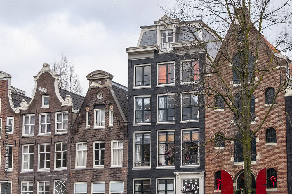Row of ancient traditional Dutch townhouses at Prinsengracht canal in Amsterdam. Prinsengracht (Prince's Canal) named after the Prince of Orange. Amsterdam, the Netherlands.