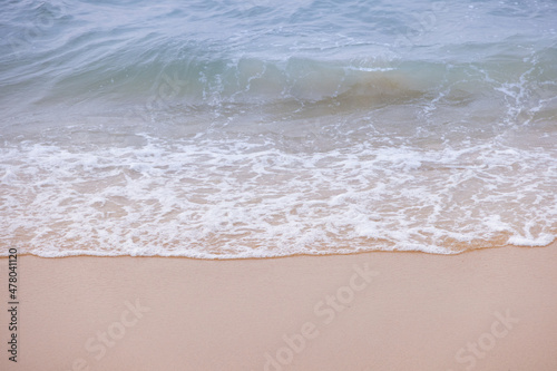 Close up ocean wave bubble on sandy beach. Background for vacation holiday and natural feeling.