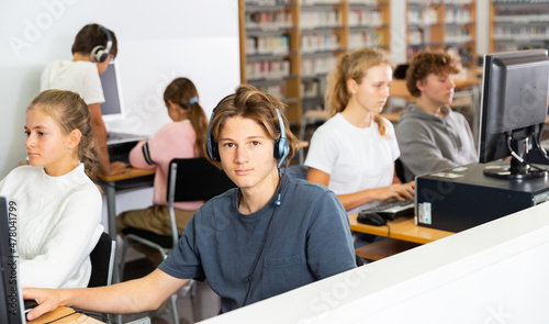 Teenage student in headphones at the computer in a school class