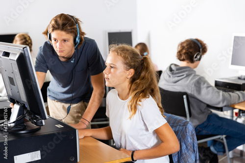 Teenager boys and girls using computers during lesson in computer class.