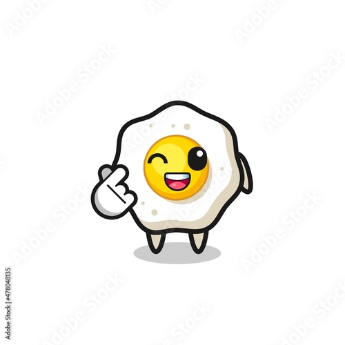 fried egg character doing Korean finger heart