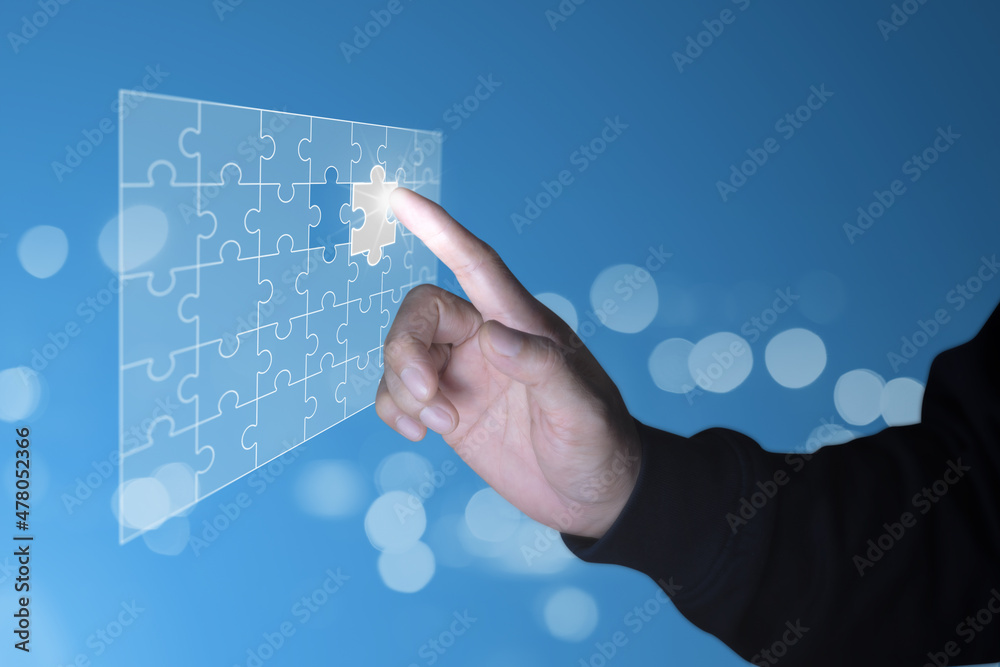 Hand touching hologram piece of jig saw puzzle place to completing the final puzzle piece.Success,game,solve problem business concept. Hand touching hologram piece of jig saw puzzle place to completing the final puzzle piece.Success,game,solve problem business concept.