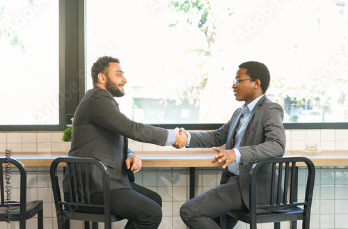 businessman getting to know each other by shaking hands and talking near glass window.concept for business relations, relationships between various stakeholders in business network