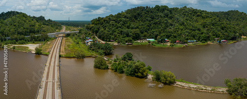 Aerial panoramic drone view of railway track across a lake in Bukit Merah, Simpang Empat Semanggol, Perak, Malaysia. photo