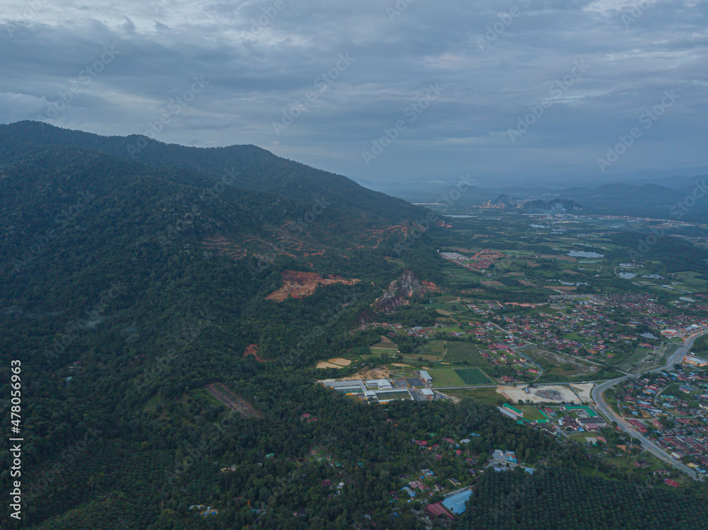 Drone shot of residential area near green mountains range at Chemor, Ipoh, Perak, Malaysia.