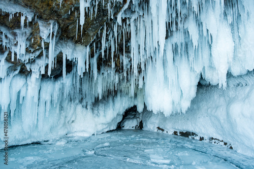 Ice cave with huge icicles on the Lake Baikal in winter. Siberia, Russia. Winter in nature.
