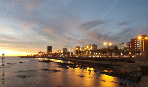 Montevideo  Uruguay city skyline at sunset. Ramirez beach at night  lights of the Rambla Sur and wall on the coast of the R  o de la Plata.