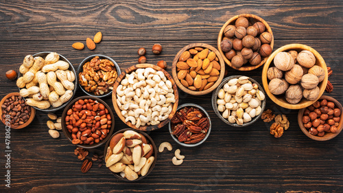 Nuts in assortment, Walnuts, pecans, almonds and other. Healthy food snack mix on wooden table background, top view
