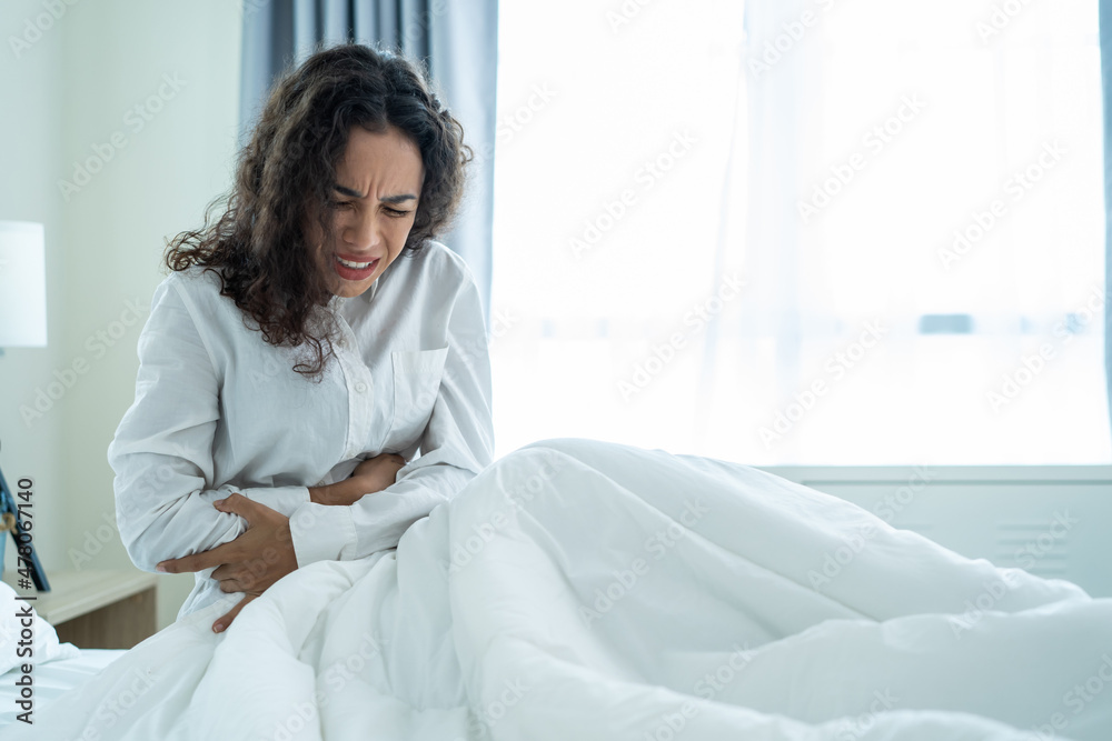 Latino beautiful sick girl in pajamas getting up from sleep in bedroom Latino beautiful sick girl in pajamas getting up from sleep in bedroom