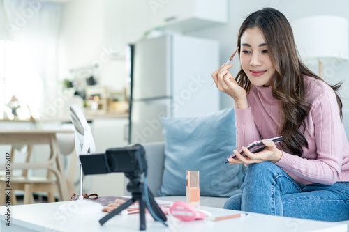 Asian female vlogger talk with camera to review the cosmetic at home. 