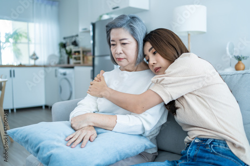 Asian loving daughter comforts upset elderly mother crying for problem