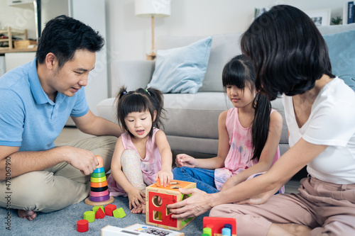 Asian happy family sit on floor  play kid toy together in living room. 