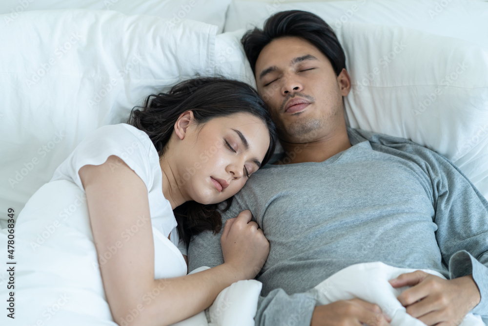 Asian attractive young couple lying down on bed to sleep in bedroom. Asian attractive young couple lying down on bed to sleep in bedroom.