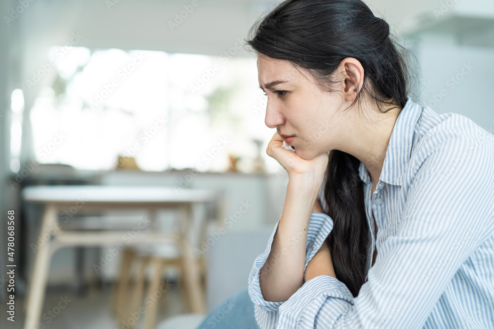Asian beautiful unhappy woman sit on sofa feel frustrated and stressed Asian beautiful unhappy woman sit on sofa feel frustrated and stressed