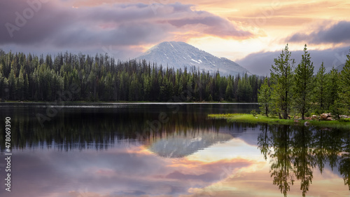 Scenic Teapot lake landscape in Wasatch national forest during evening time , Coniferous trees by the lake shore with perfect reflections.
